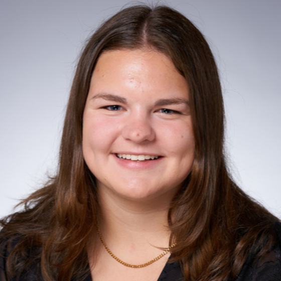 Christina Conrad, Jr. Environmental Scientist, poses in business attire in front of a light gray background.